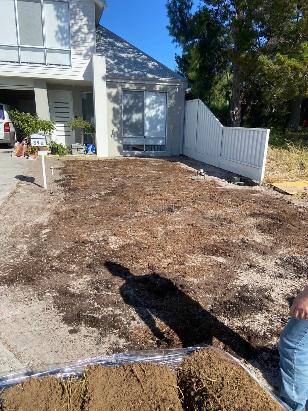 Topsoil and compost spread to prepare the turf bed.